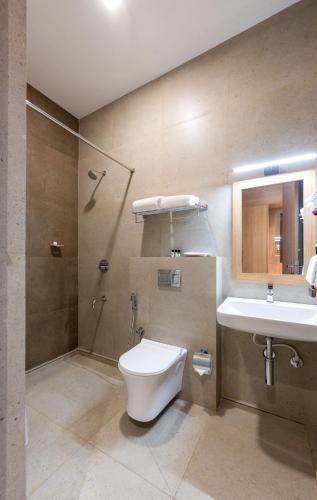 a bathroom with a toilet and a sink at HOTEL ACHYUT in Tiruppūr