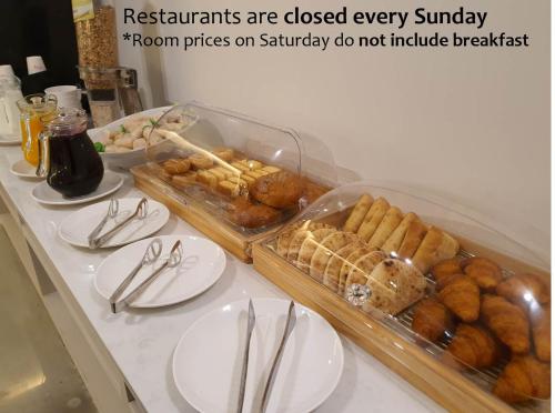 a table with plates of pastries and utensils on it at Denbasta Central Hotel Seomyeon in Busan