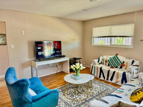 a living room with blue chairs and a tv at Chic Home with Expansive Backyard- duplex back unit in San Mateo