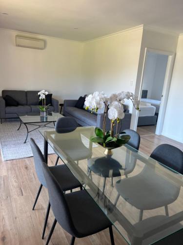 a living room with a glass table and chairs at Country Living in Dubbo