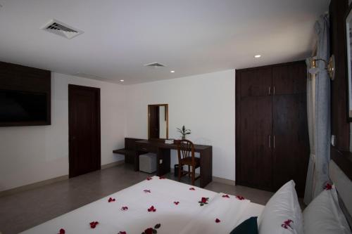a bedroom with a bed and a desk and a table at Vrest Hotel in Phnom Penh