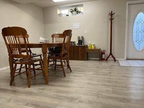a dining room with a wooden table and chairs at Licensed spacious basement suite with one king-size bed in Chilliwack