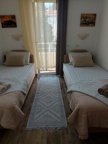two beds sitting in a room with a window at Villa Lyudmila in Utjeha