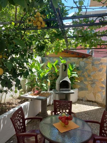 an outdoor patio with a table and chairs and a stove at Villa Lyudmila in Utjeha
