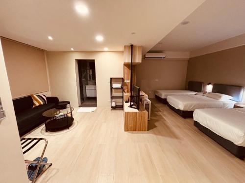 a hotel room with two beds and a couch at Chao Zhou 86 B&B in Chaozhou