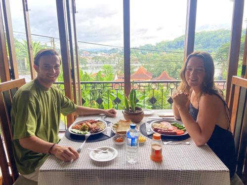 a man and a woman sitting at a table with food at Sesatha lake Kandy in Kandy