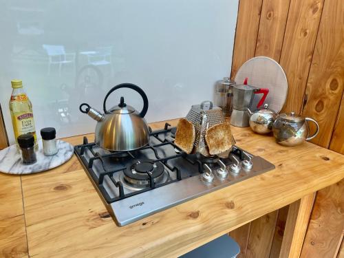 a tea kettle sitting on top of a stove at River Song Retreat Golden Bay in Onekaka