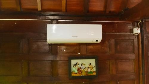 a white projector hanging on a wall with a picture at Cokro Hinggil - Traditional View in Sleman