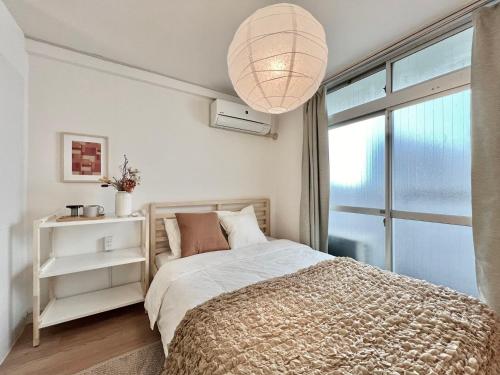 a bedroom with a bed and a large window at Shinjuku YC Hostel-SJ0399 in Tokyo