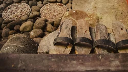 a pile of wooden shoes next to a pile of rocks at Cokro Hinggil - Traditional View in Sleman