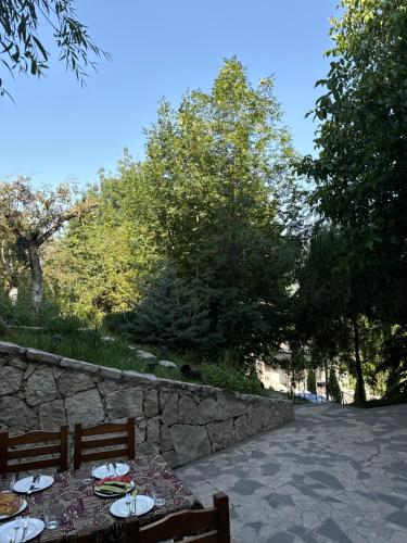 a table with plates on it next to a stone wall at Verin Tun in Dilijan