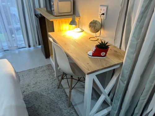 a wooden desk with a plant on it in a bedroom at Cozy Hide in East London