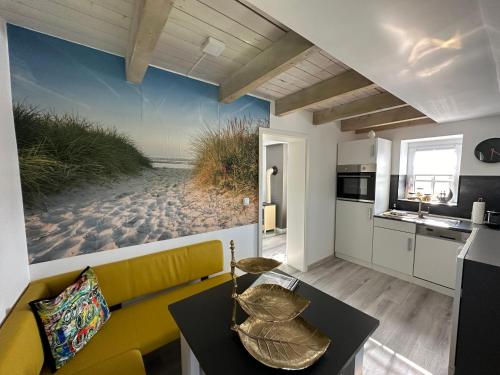 een woonkamer met een gele bank en een strandmuurschildering bij "Huus ant Diek", Ferienhaus mit Maisonette Wohnung in Deichnähe, Nähe Norddeich in Norden