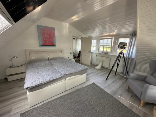 een slaapkamer met een bed, een bureau en een stoel bij "Huus ant Diek", Ferienhaus mit Maisonette Wohnung in Deichnähe, Nähe Norddeich in Norden
