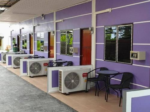 a room with a purple wall with chairs and machines at Chanita Resort Soidao in Chanthaburi