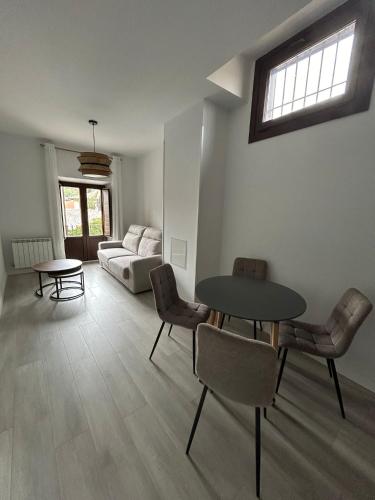 a living room with a table and chairs and a couch at Tu Casa San Marcos in Segovia