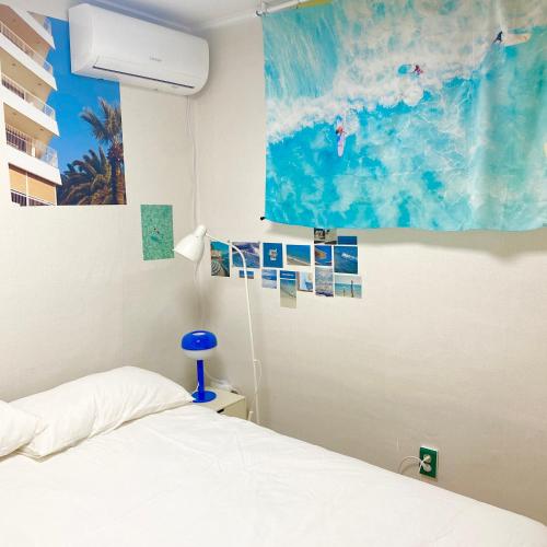 a bedroom with a bed and a painting on the wall at Haekong's House in Seoul