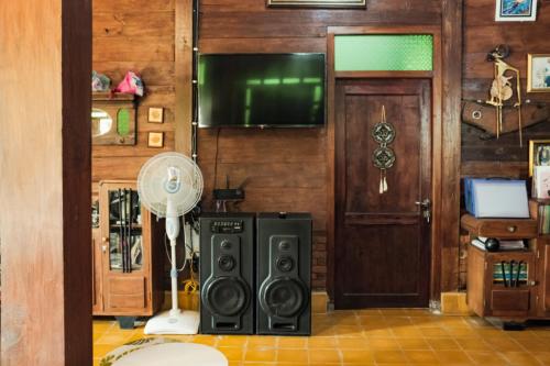 a room with a fan and a speaker and a door at Cokro Hinggil - Traditional View in Sleman