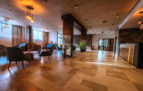 a lobby with a table and chairs and a fireplace at Хотел Релакс in Kazanlŭk