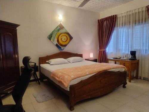 a bedroom with a bed and a table and a window at Sousa Residence in Bambalapitiya