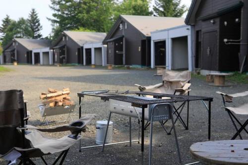 a picnic table and chairs in front of a building at Starry Sky Cottage 13 in Kitami