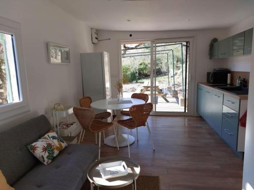 a kitchen and a living room with a table and chairs at Maisonnette au cœur de la nature in Néoules