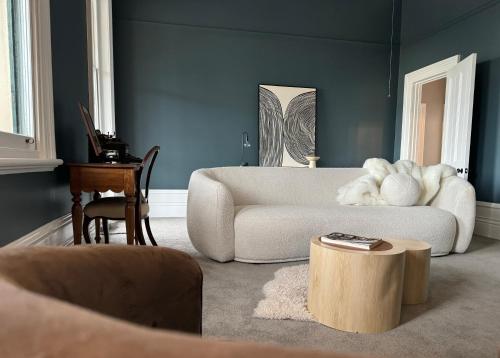 a living room with a white couch and a table at Treehouse Hideouts Balcony Apartment - Port of Echuca Townhouse in Echuca