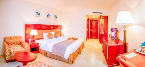 a hotel room with a large bed and a chair at Sai Gon Rach Gia Hotel in Rach Gia