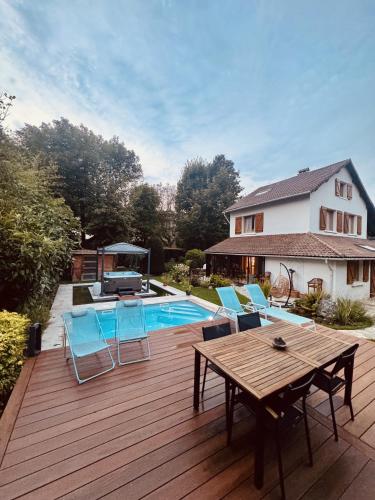 - une terrasse avec une table et des chaises à côté de la piscine dans l'établissement Villa MX LE PECQ, à Le Pecq