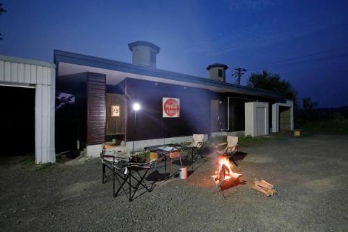a group of chairs and a fire in front of a building at Starry Sky Cottage 15 in Kitami