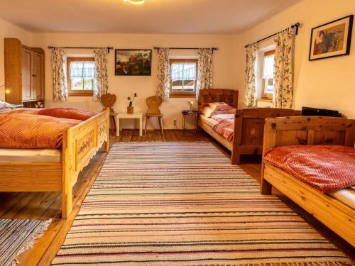 a bedroom with two beds and a rug at Historic farmhouse 200 years old meets new in Breitenbach am Inn