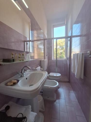 a white bathroom with a sink and a toilet at Hotel Villa Tiziana in Marina di Pietrasanta