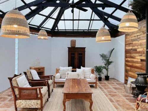 a living room with chairs and a wooden table at Tranquil Hideaway near the City- with Patio Lounge in Glenunga
