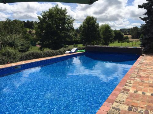 une piscine avec de l'eau bleue dans une cour dans l'établissement La Soulterie, à Crouttes