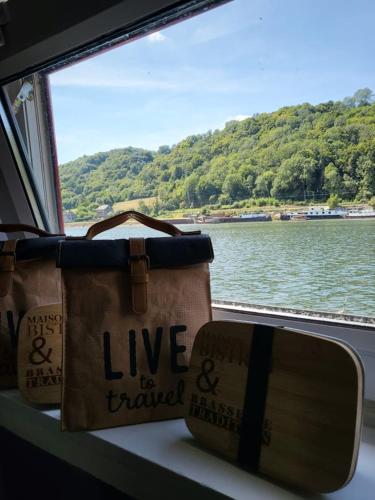 a window with two bags sitting on a boat at Une perle ! Péniche complète pour 8 sur la Meuse, région Namur in Andenne