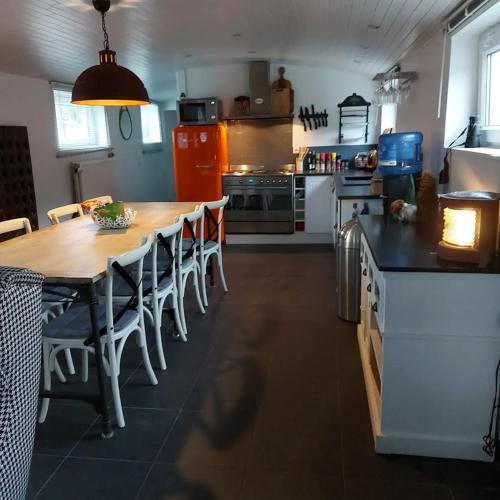 a kitchen with a large wooden table and chairs at Une perle ! Péniche complète pour 8 sur la Meuse, région Namur in Andenne