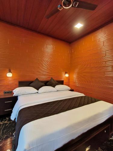 a bedroom with two beds and a wooden wall at Betel Brooks Resort in Maraiyūr