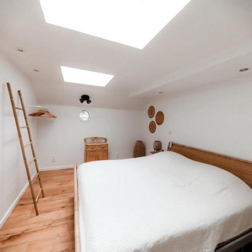 a bedroom with a white bed and a skylight at Une perle ! Péniche complète pour 8 sur la Meuse, région Namur in Andenne