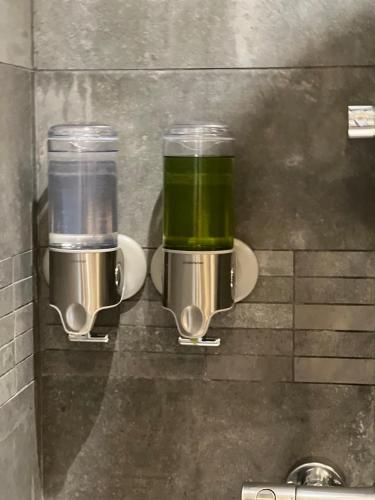deux tasses de liquide vert sont fixées à un mur dans l'établissement Superbe appartement proche du Marais, à Paris
