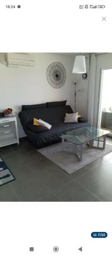 un salon avec un canapé et une table en verre dans l'établissement 2 pièces terrasse vue mer, piscine, parking, à Sainte-Maxime