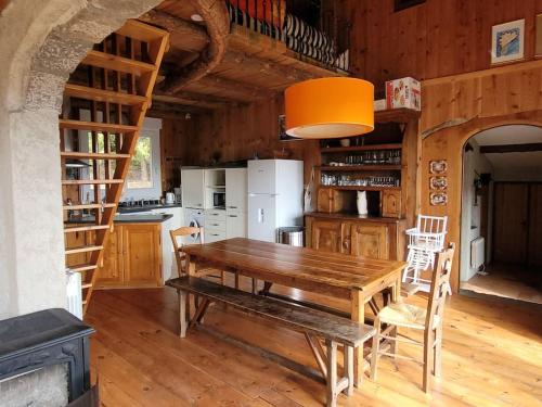 une salle à manger avec une table en bois et une cuisine dans l'établissement Gite la Petite Ruche, à Mazet-Saint-Voy