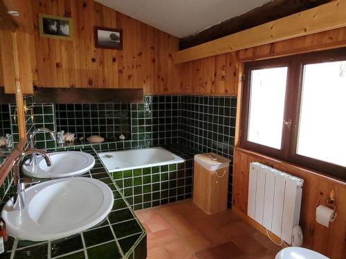 une salle de bain avec deux lavabos et une baignoire dans l'établissement Gite la Petite Ruche, à Mazet-Saint-Voy