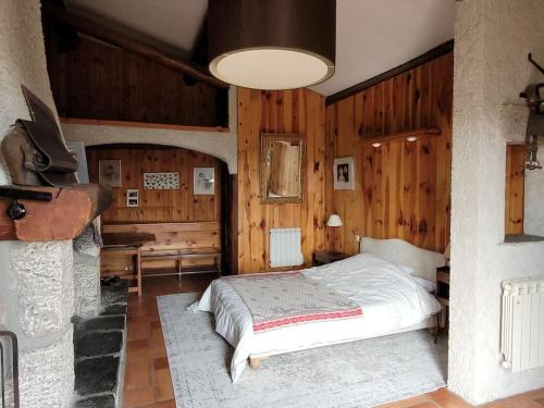 une chambre avec un lit dans une pièce aux murs en bois dans l'établissement Gite la Petite Ruche, à Mazet-Saint-Voy