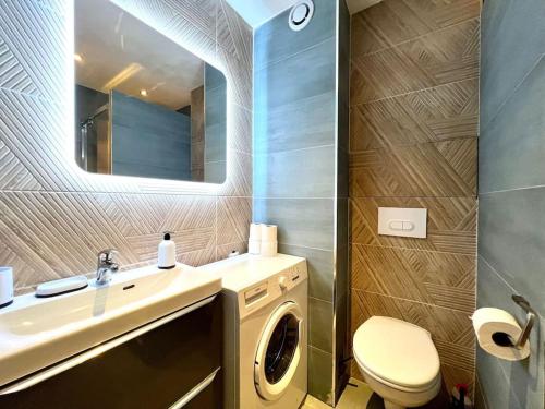 une salle de bain avec une machine à laver et un lavabo dans l'établissement California - Clim Parking, à Nîmes
