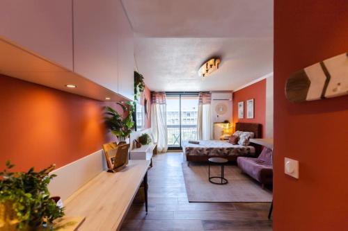 - un salon avec des murs orange et un canapé dans l'établissement California - Clim Parking, à Nîmes