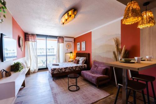 un salon avec un lit et une table dans l'établissement California - Clim Parking, à Nîmes