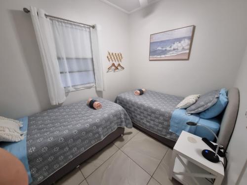 a bedroom with two beds and a couch and a window at GUESTHOUSE on REGENT Bed & Breakfast in Caloundra