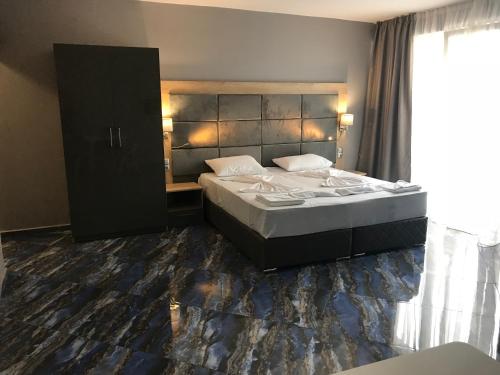 a bedroom with a large bed and a large window at Marina Beach Apartments Pomorie in Pomorie