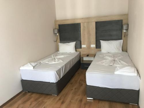 two beds in a small room with wooden floors at Marina Beach Apartments Pomorie in Pomorie