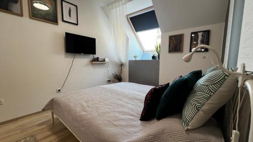 a bedroom with a bed with pillows and a window at Westend - studio above the city in Budapest